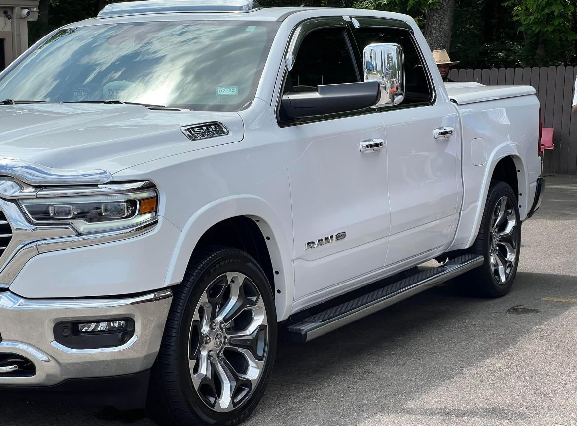 A white Ram 1500 truck parked in an auto detailing shop
