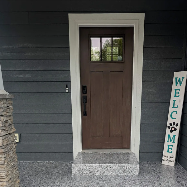 A brown door with a welcome sign in front of it