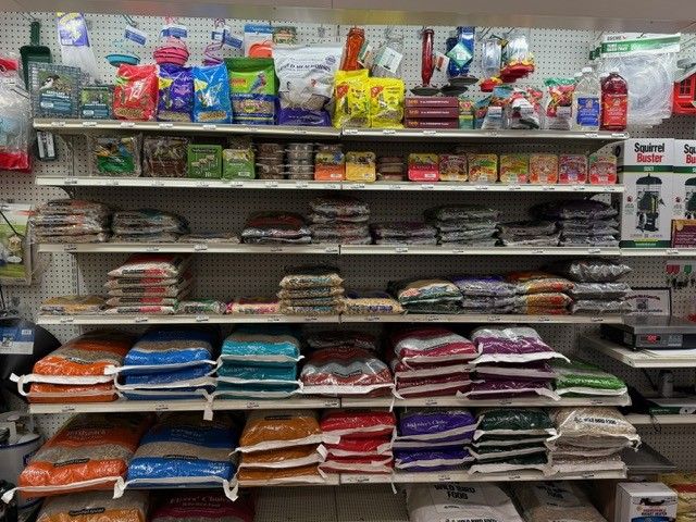 Shelves stocked with various pet food bags and supplies in a retail store.