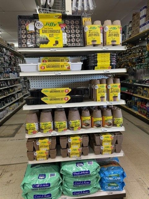 Shelves stocked with various gardening kits and supplies at a store.