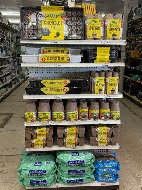 Shelves stocked with gardening supplies including starter kits, soil, and pots.