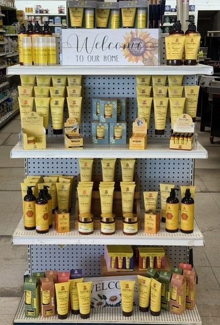 A retail display showcasing various yellow skincare products on shelves. A welcome sign with a sunflower is centered.