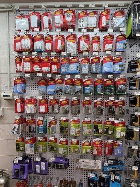 Display of packaged electrical components on a pegboard in a hardware store.