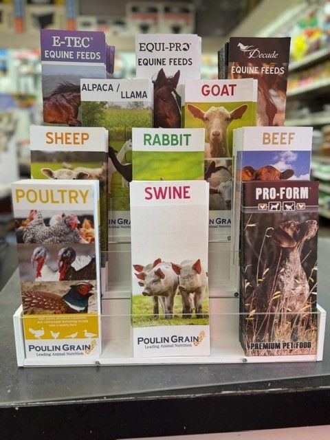 Display of animal feed brochures at a store. Brochures cover topics like poultry, swine, and beef.