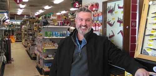 A man in a black jacket is standing in a store