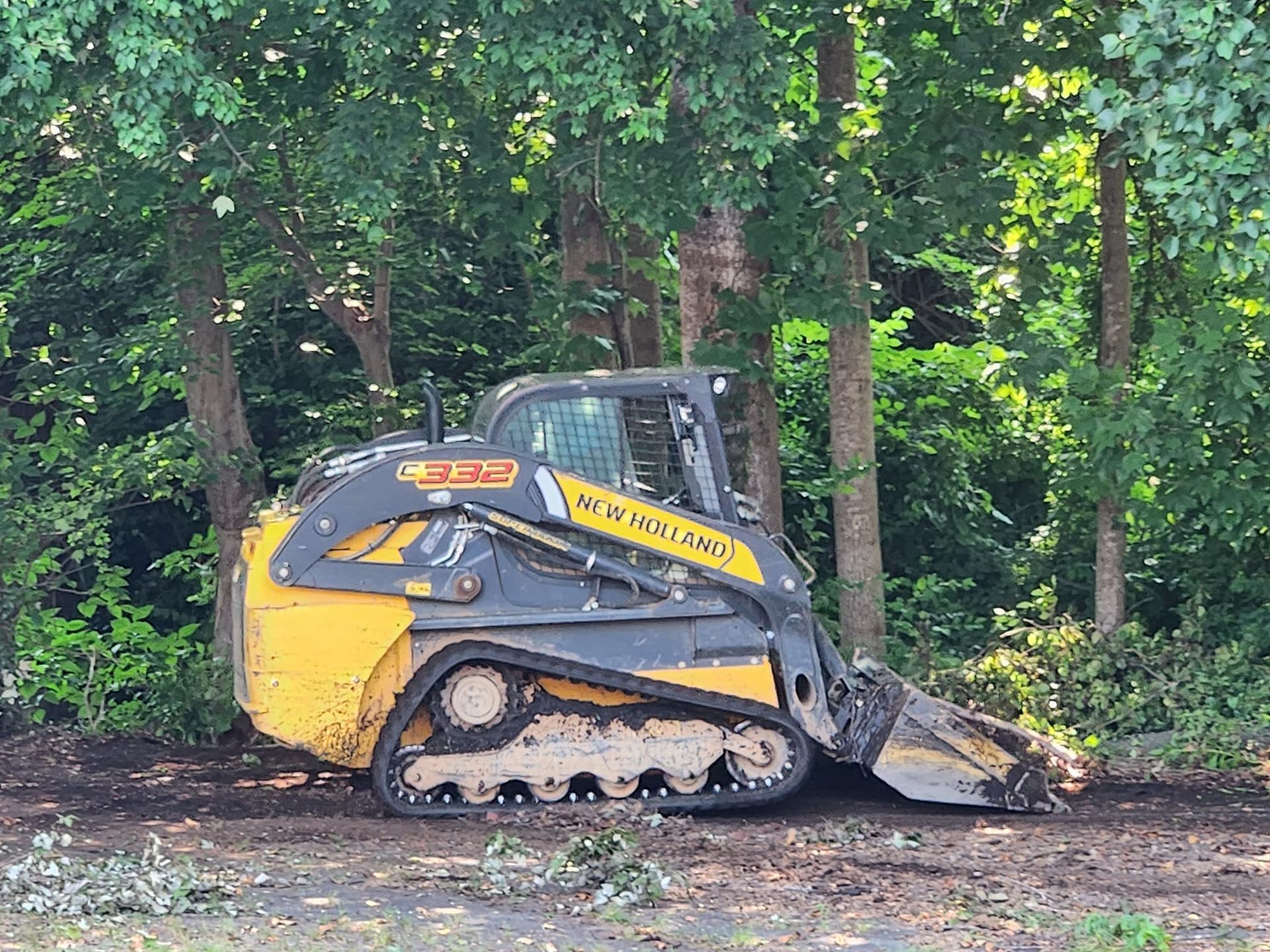 A bulldozer is sitting in the middle of a forest.