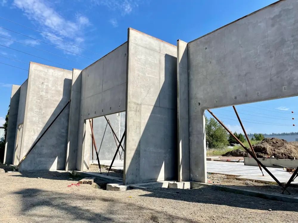 Precast concrete walls for a building under construction, supported by temporary diagonal steel braces.