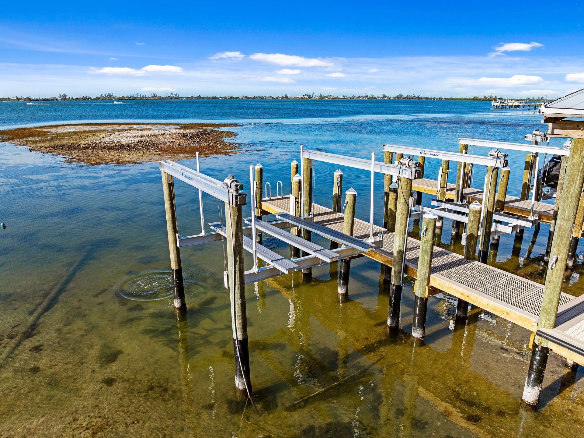Wooden boat docks on a clear day with a blue sky and water.