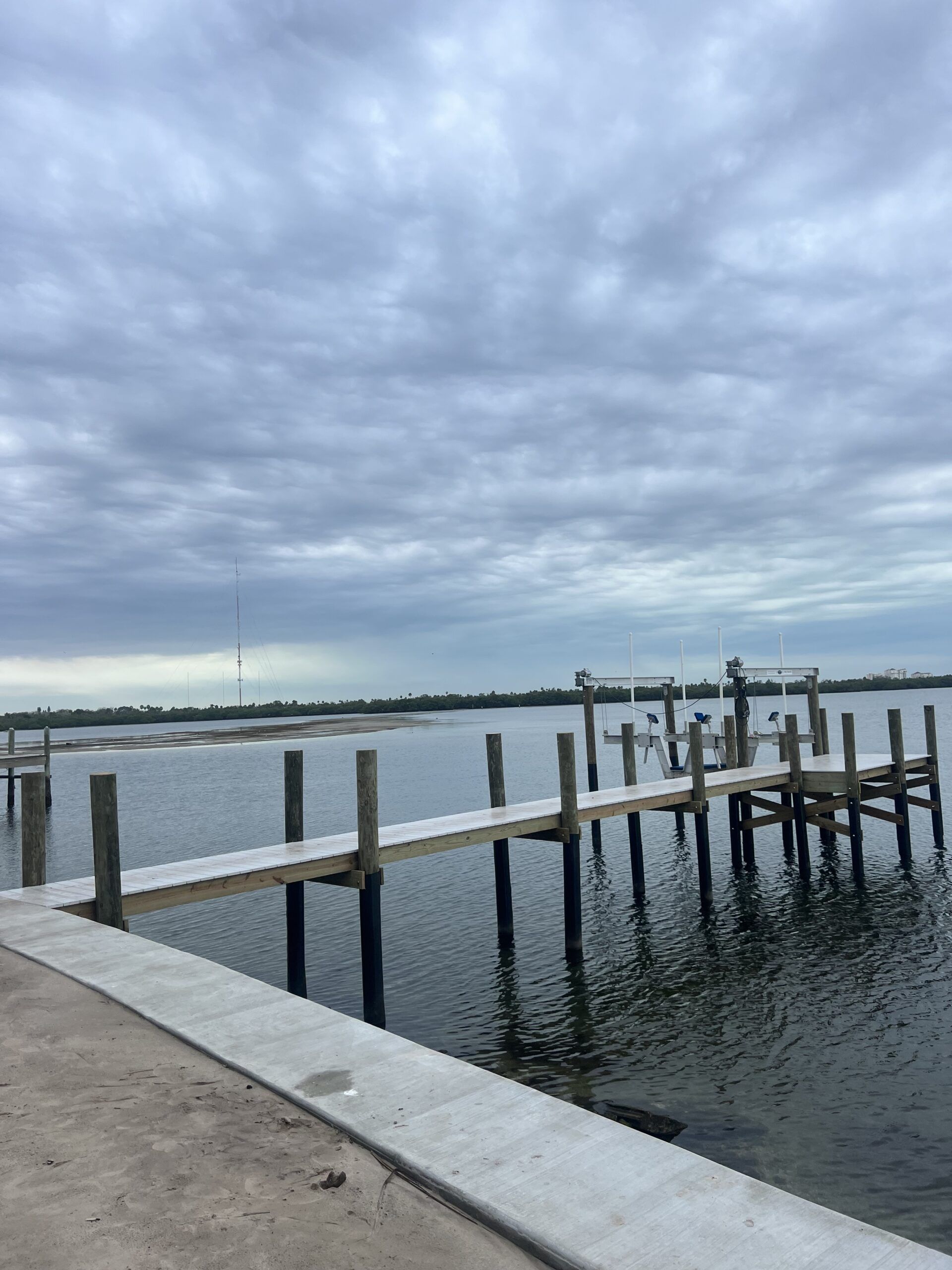 Wooden docks extending into calm water under a cloudy sky.