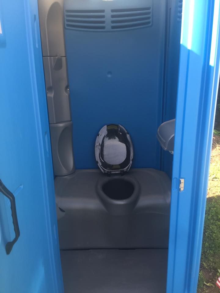 Blue portable toilet interior with a toilet and a sink.