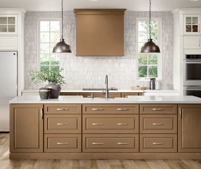 Kitchen with brown cabinets, white countertops, two windows, and pendant lights.
