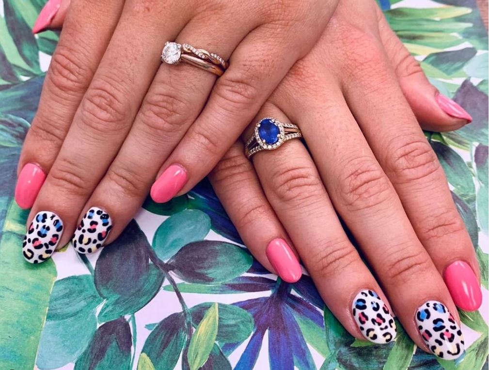 A close up of a woman 's nails with a ring on her finger.