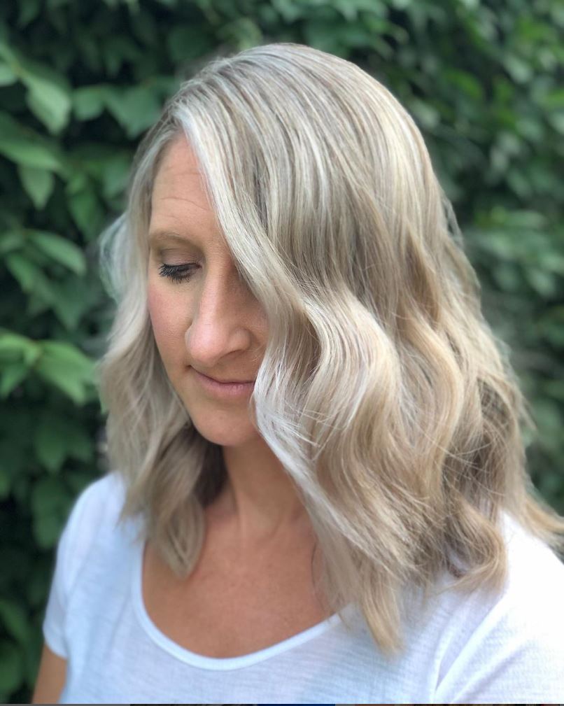 A woman with blonde hair is wearing a white shirt