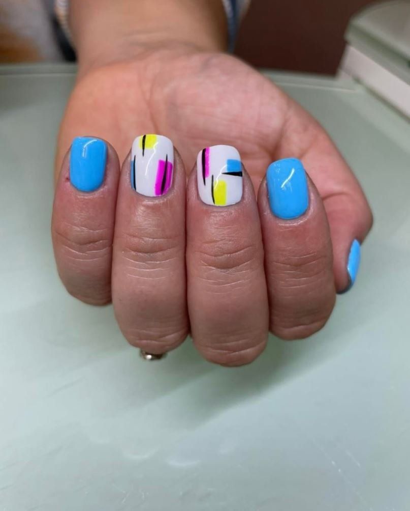 A close up of a woman 's hand with blue and white nails
