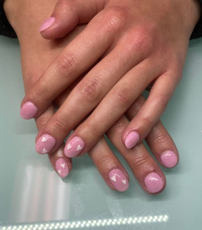 A close up of a woman 's hands with pink nails