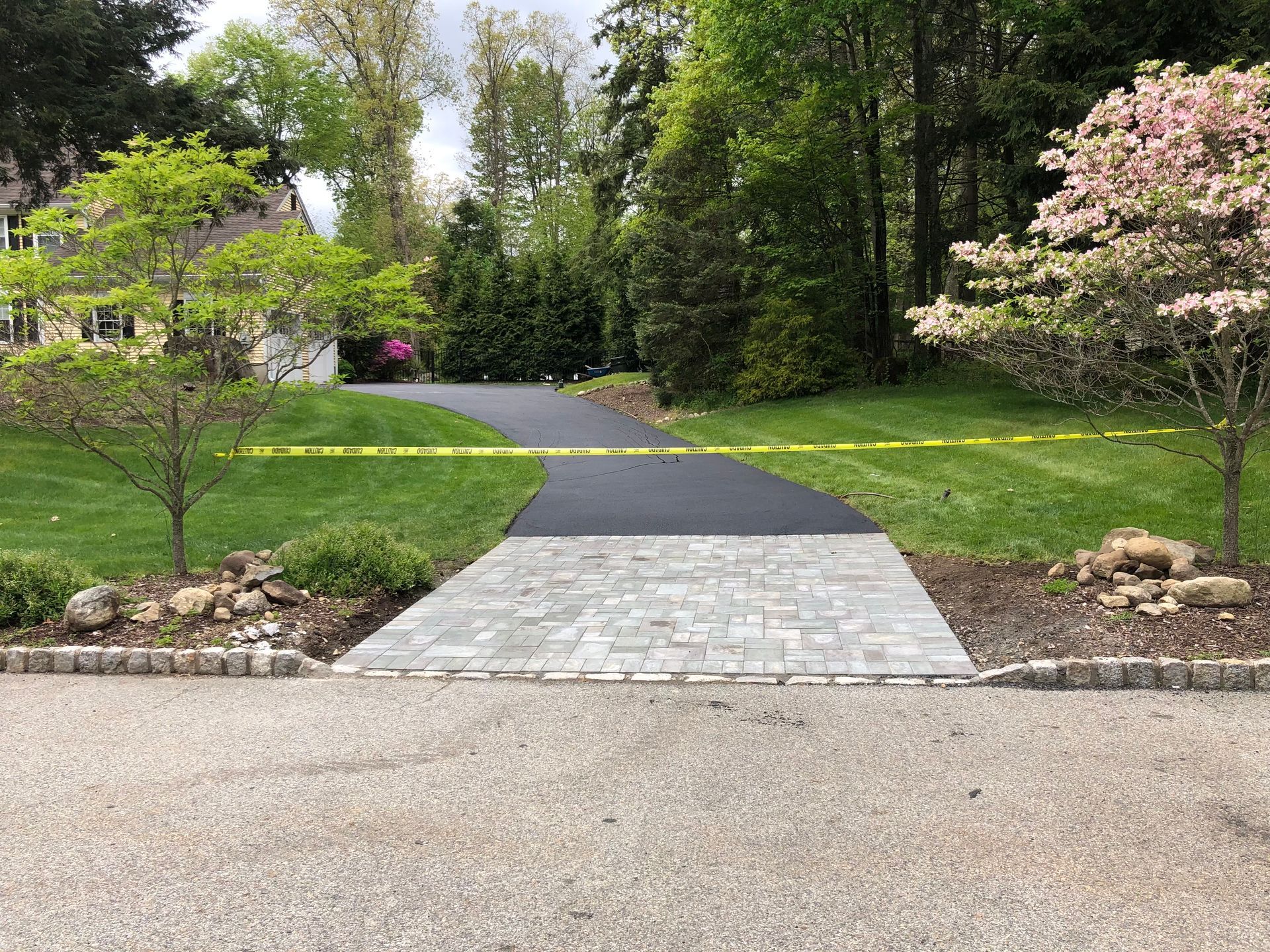 A driveway with a brick walkway leading to a house.