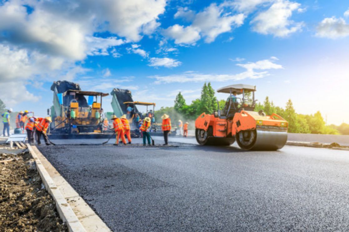 A group of construction workers are working on a road.