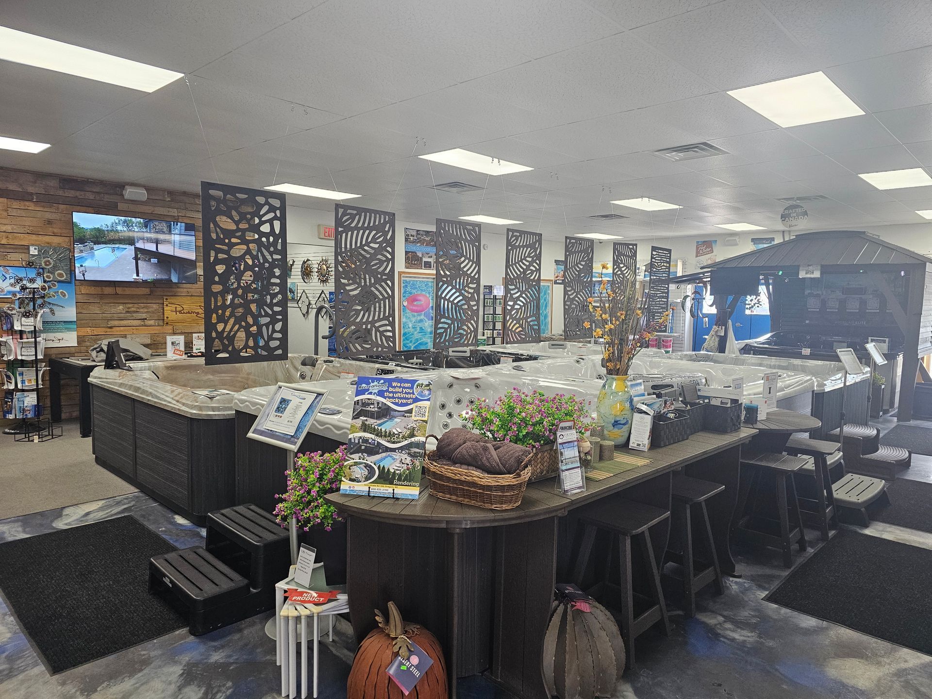 Bright casino buffet with food island, floral centerpiece, patterned columns, and wall of screens
