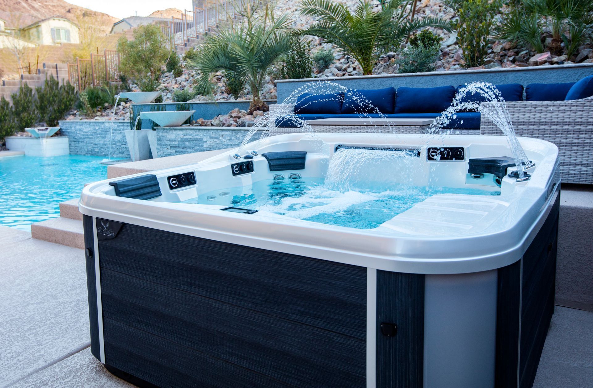 Outdoor hot tub bubbling beside a backyard pool and patio seating area