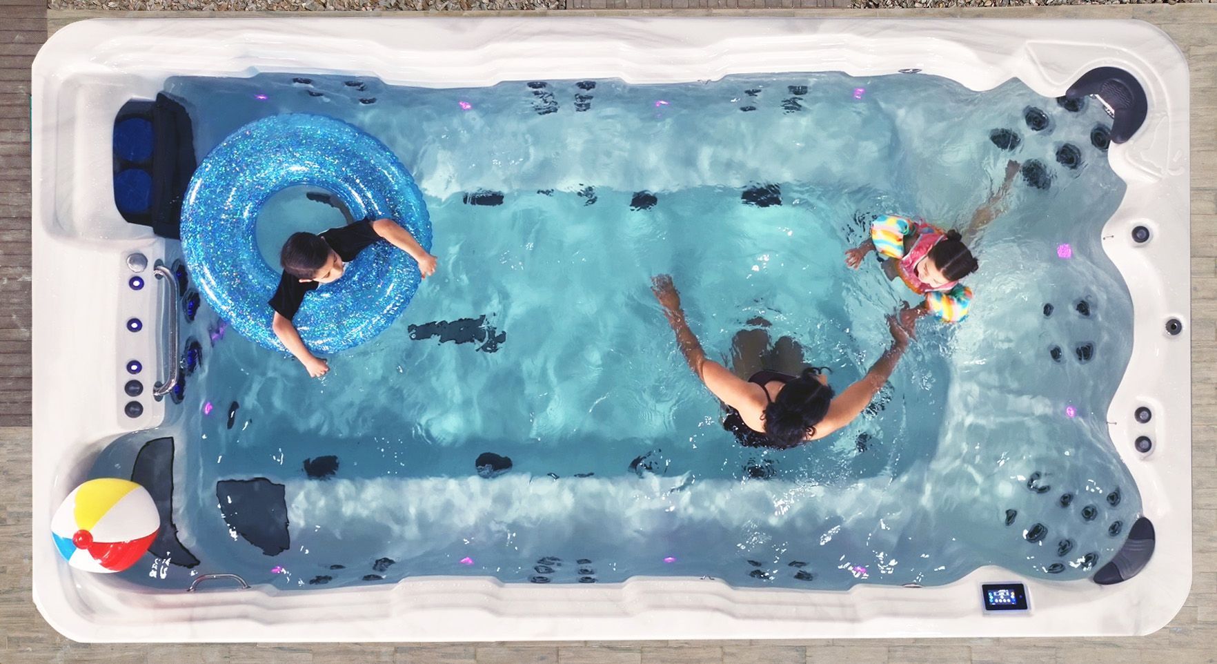 Overhead view of two people in a small pool, one on a blue float and one floating near the center.