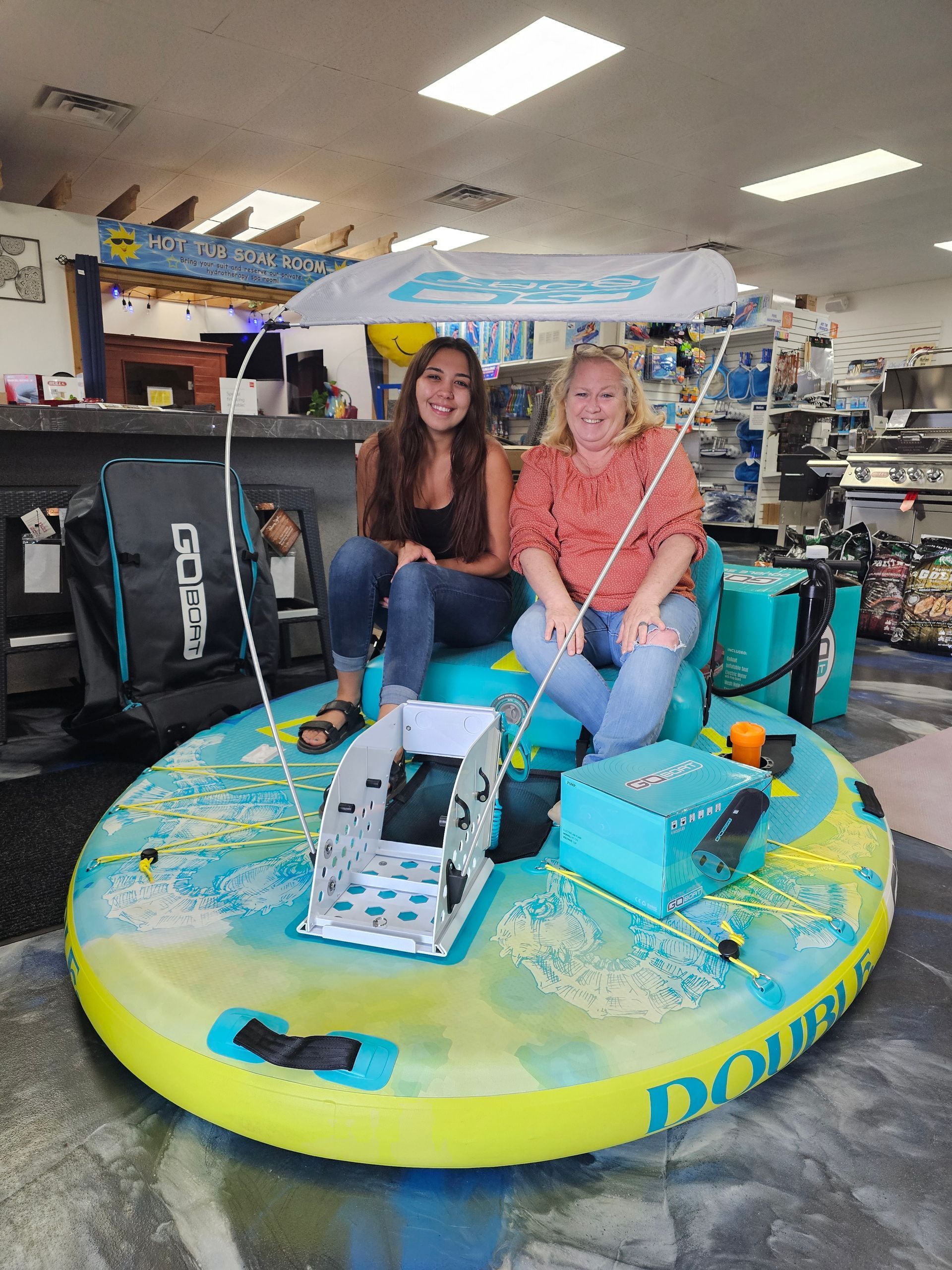 Two women smiling on a colorful round display with a treadmill in a store.
