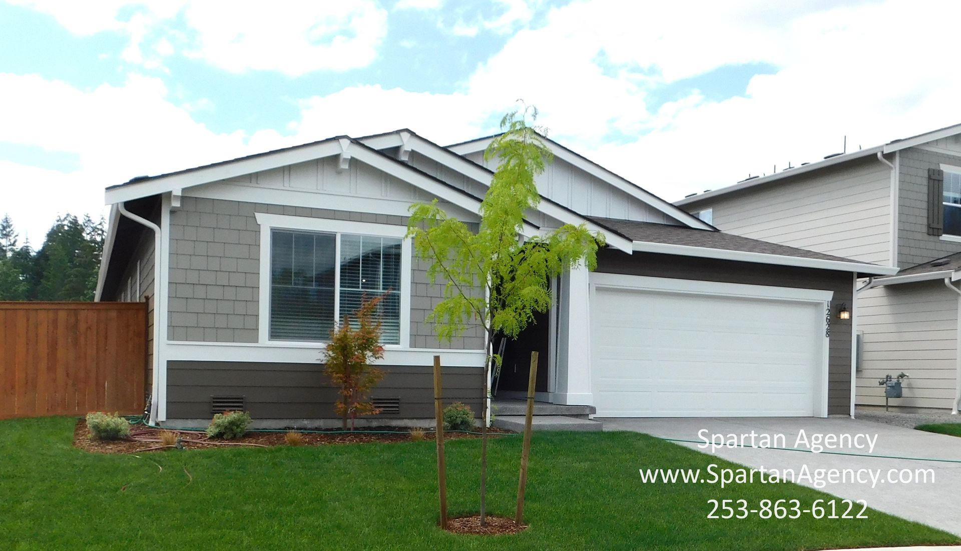 Single story home light brown and tan with white garage door
