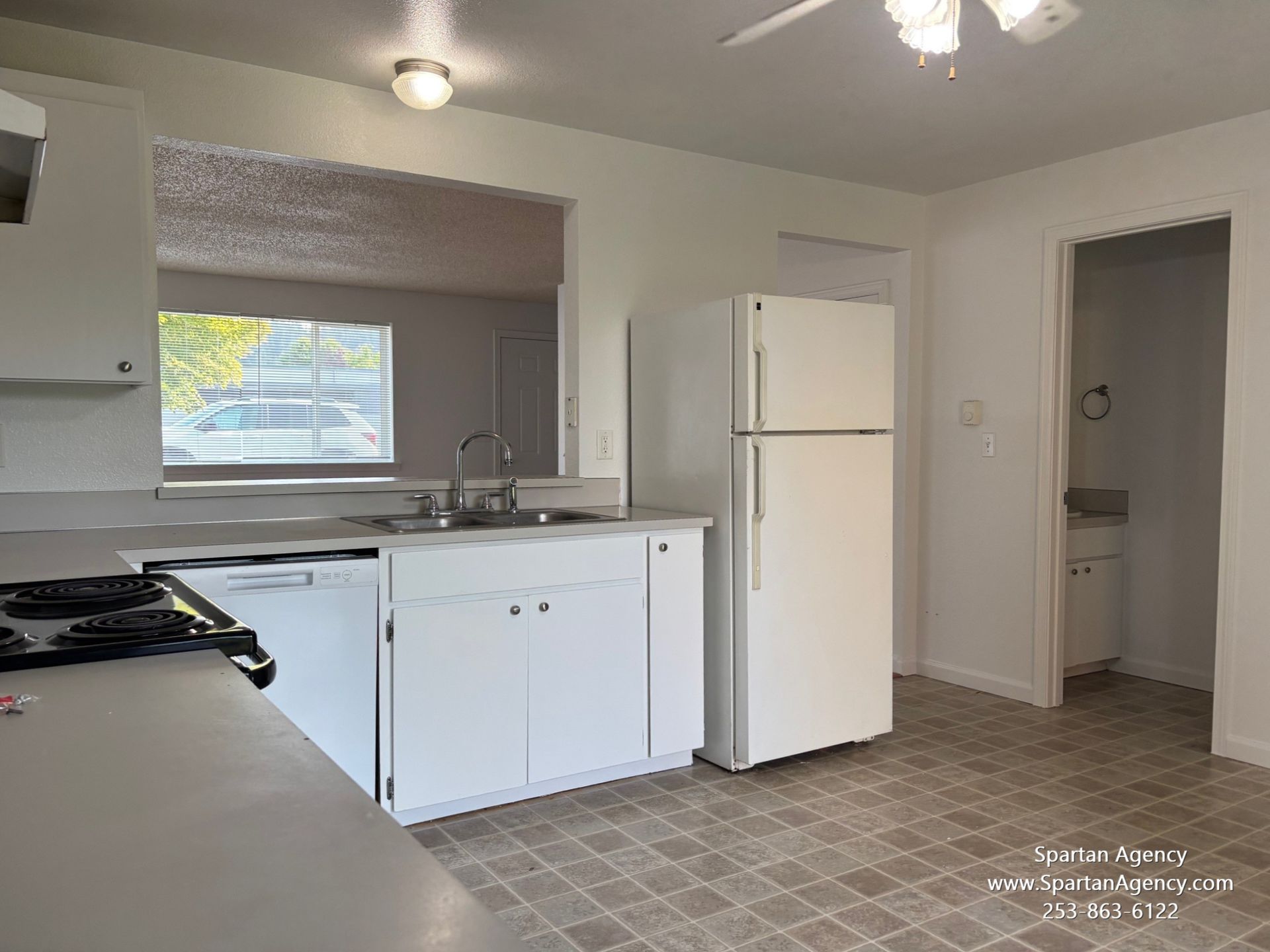 A kitchen with white cabinets and a white refrigerator