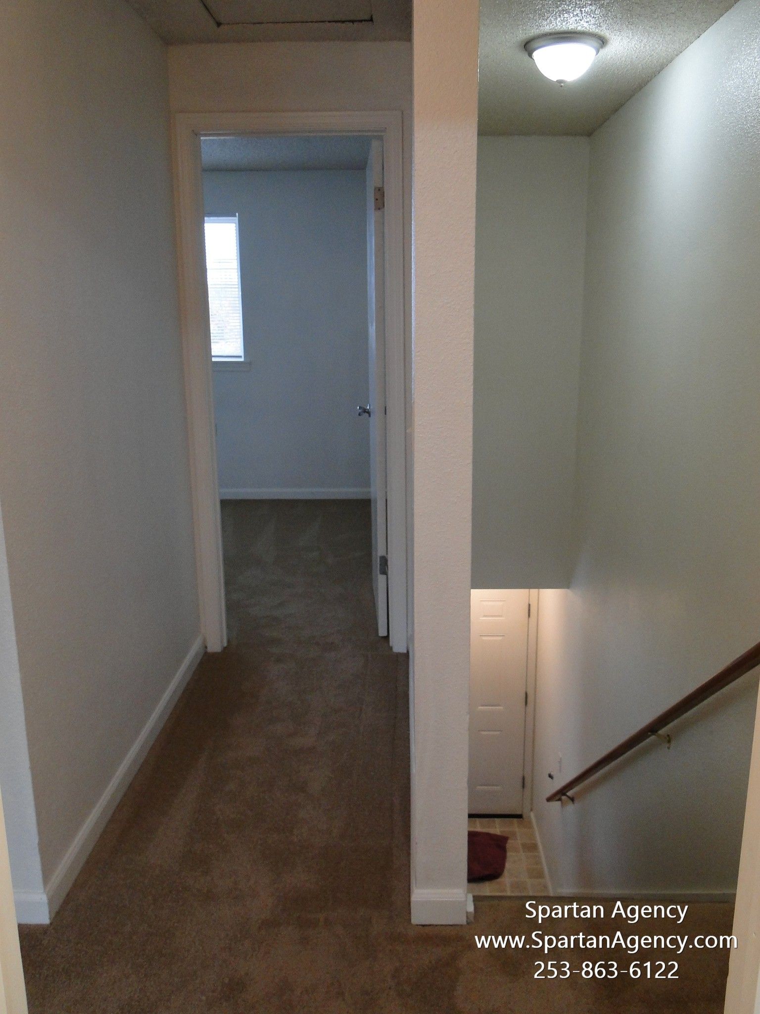 An empty hallway with stairs leading up to the second floor