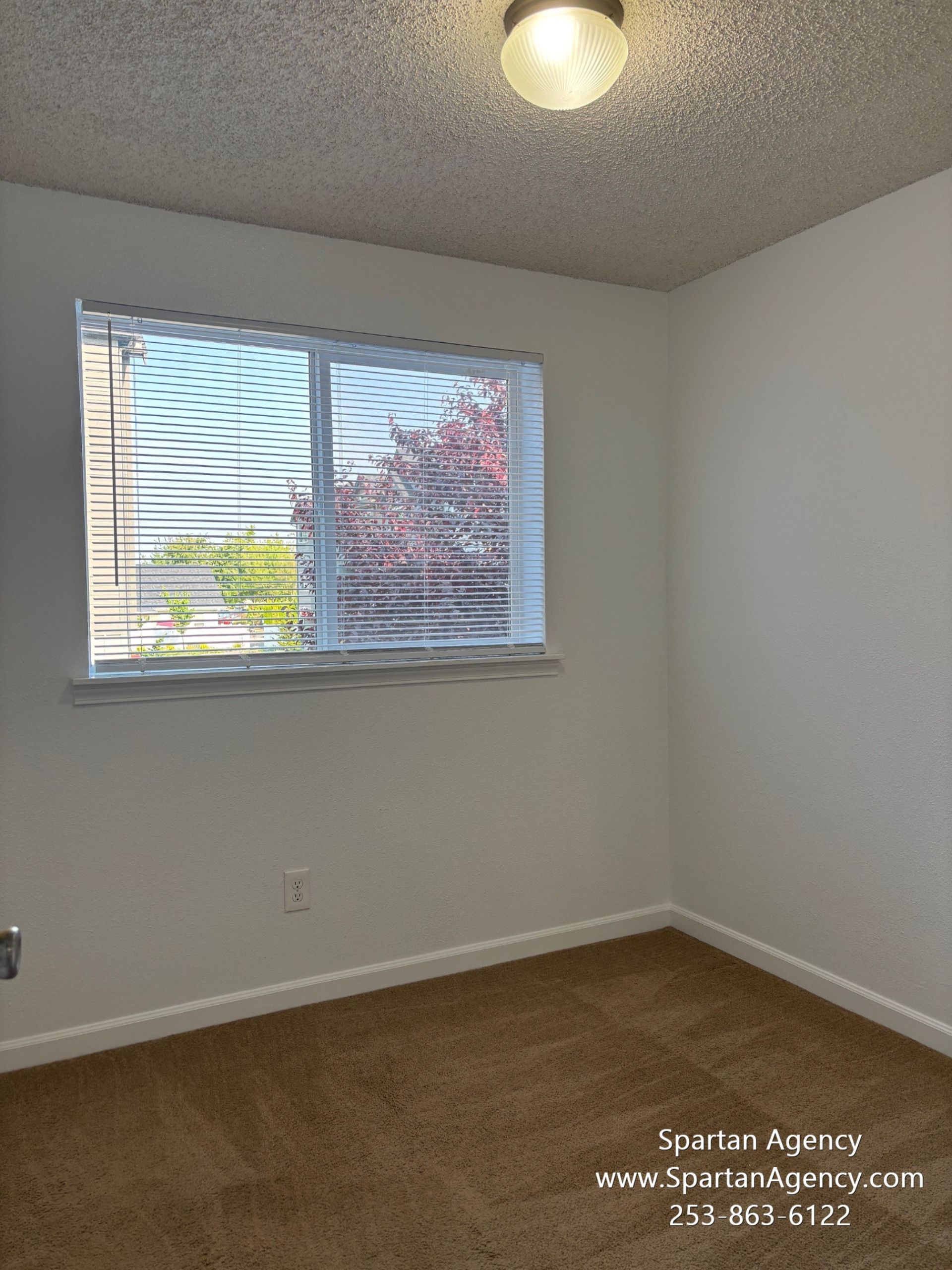 An empty room with a window and a light on the ceiling