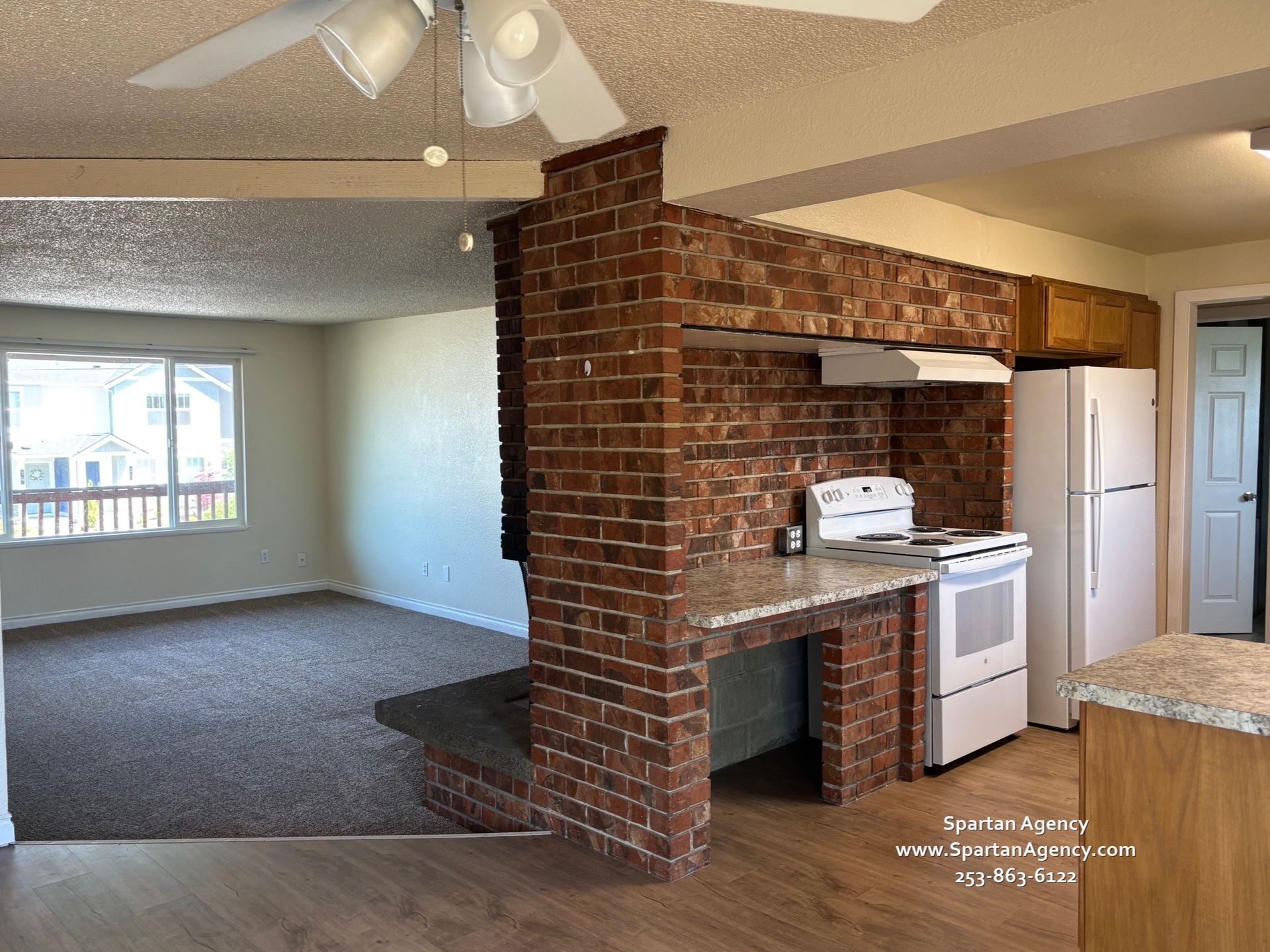 There is a brick wall between the living room and the kitchen