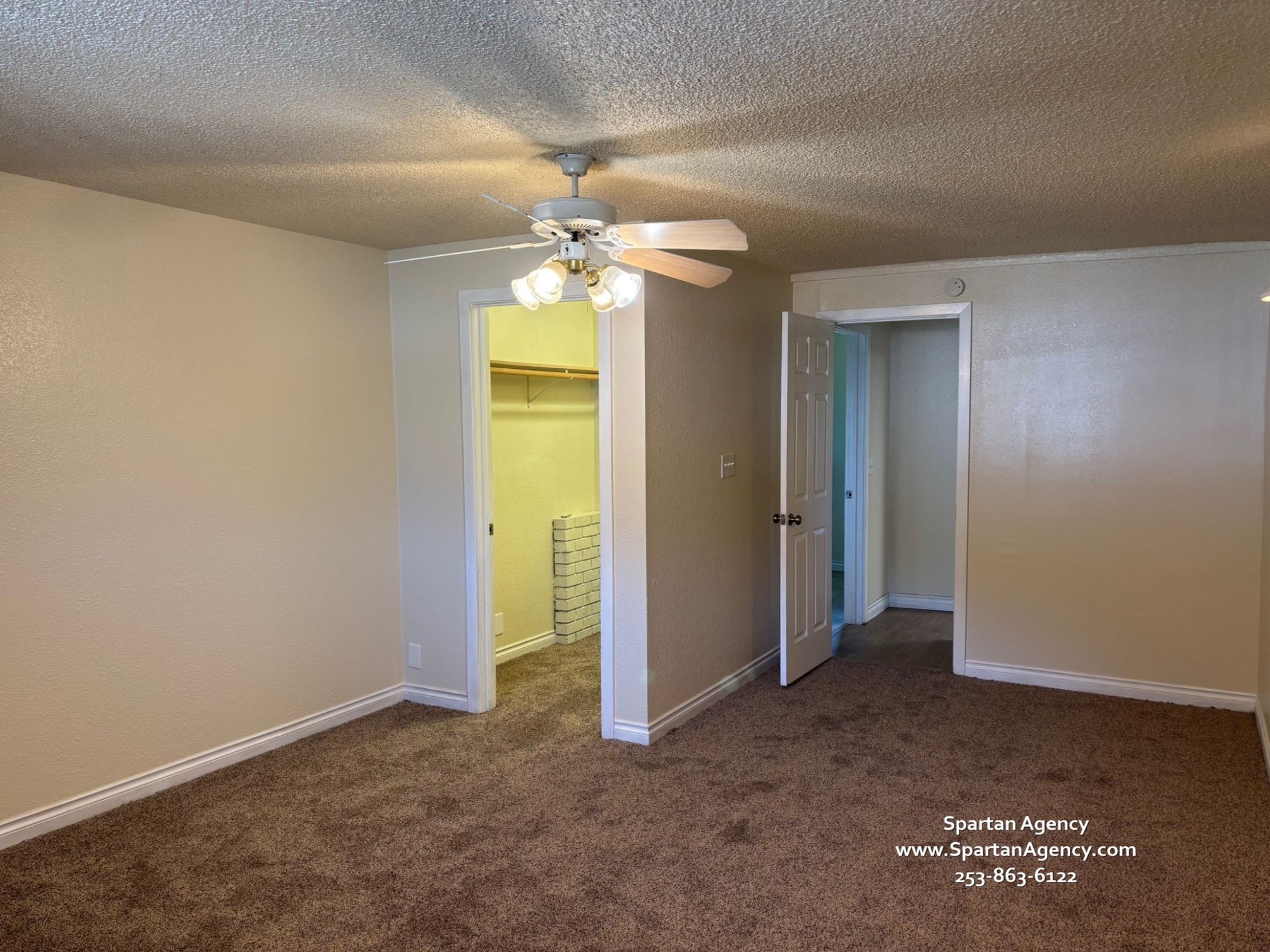 An empty bedroom with a ceiling fan and a walk in closet