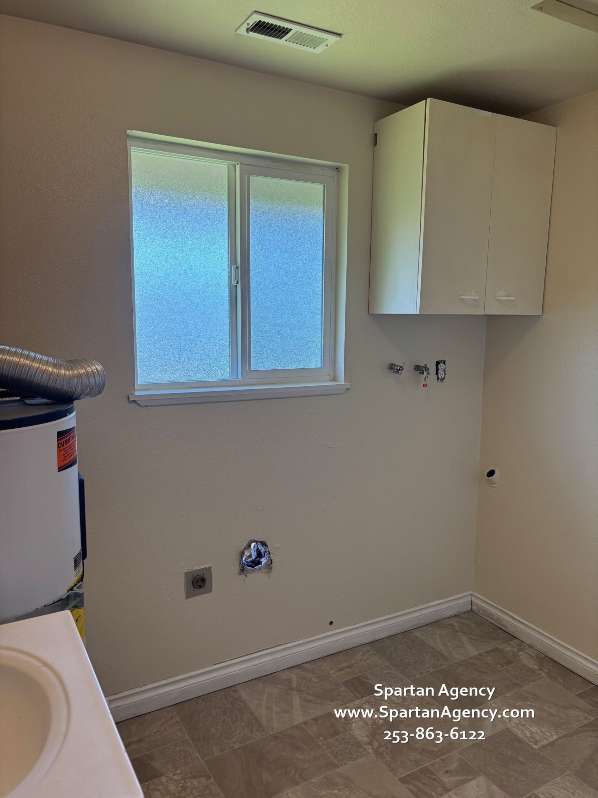A laundry room with a sink and a window