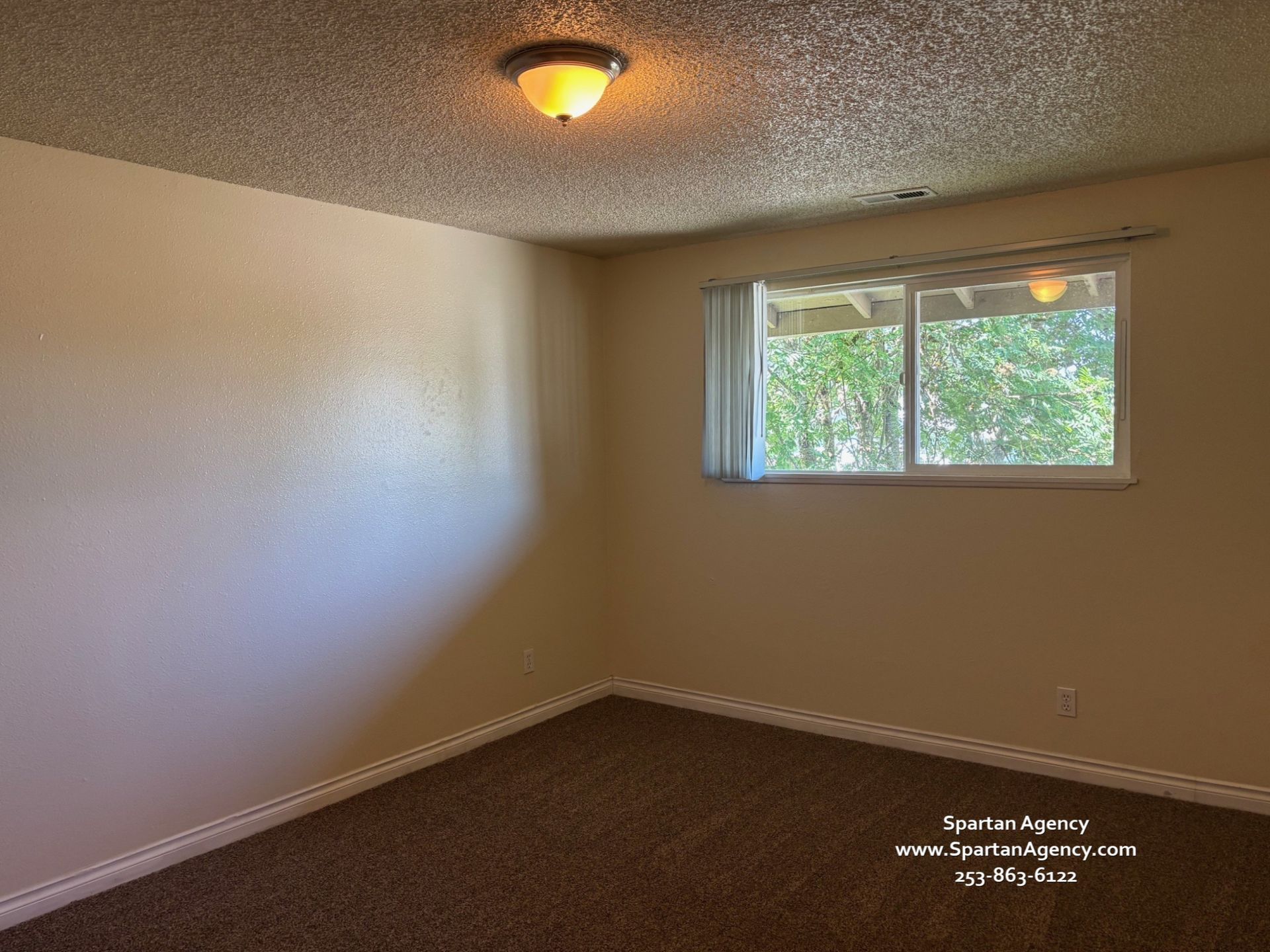 An empty room with a window and a light on the ceiling