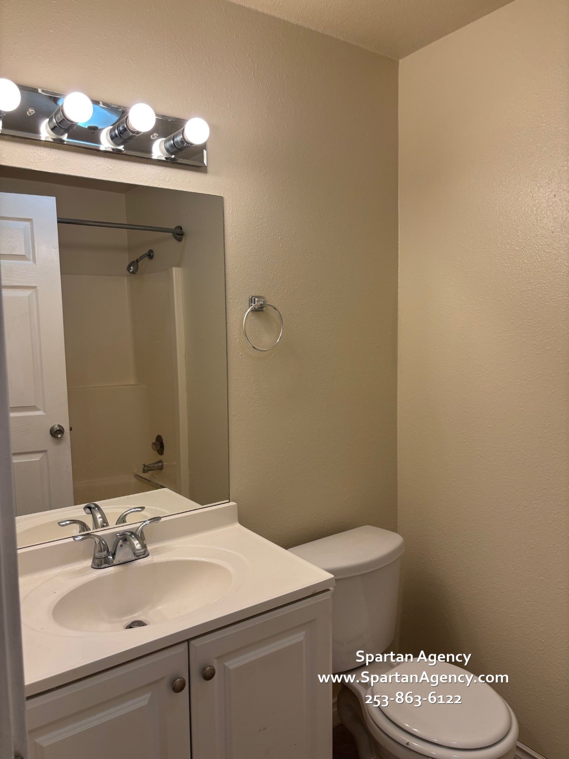 A bathroom with a toilet a sink and a mirror