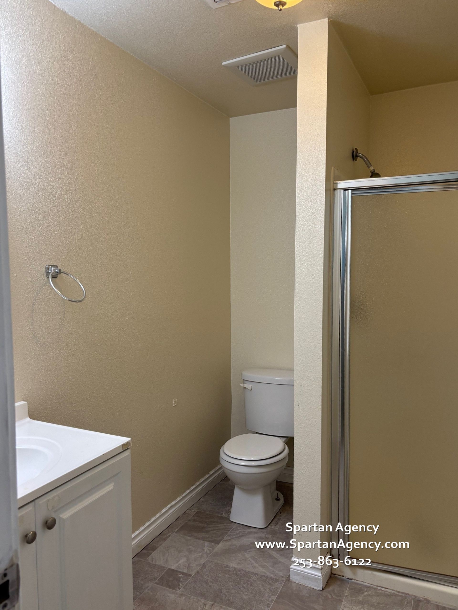 A bathroom with a toilet, sink, and shower