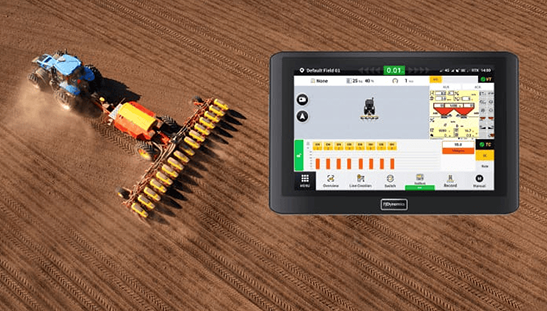 Tractor planting with a control screen displaying real-time data about the planting process.