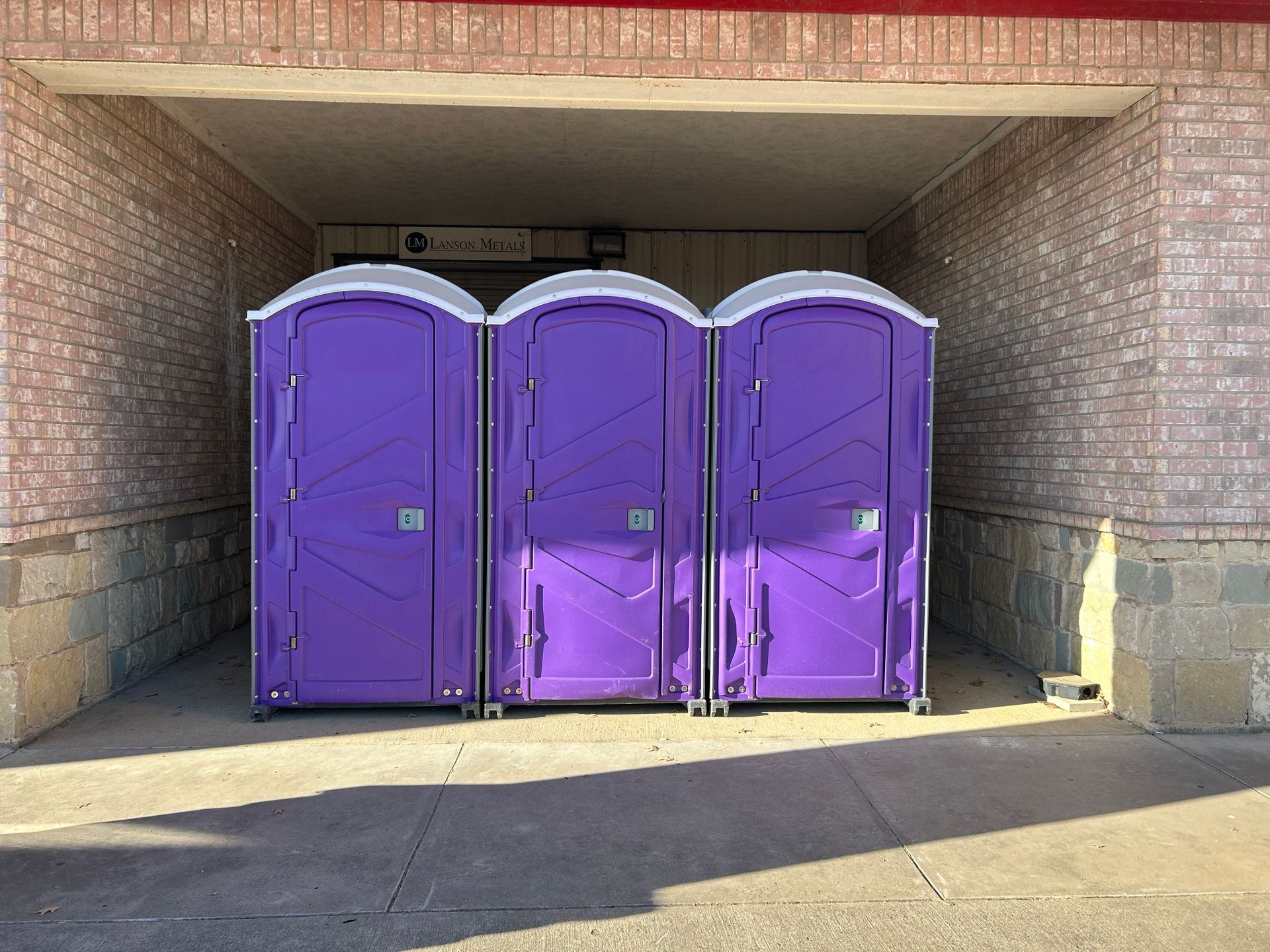 3 purple portable toilets
