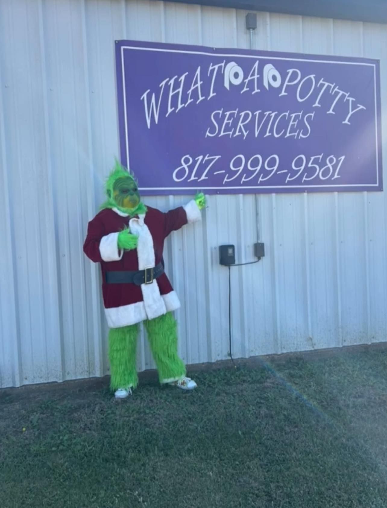 The Grinch in costume points at a 