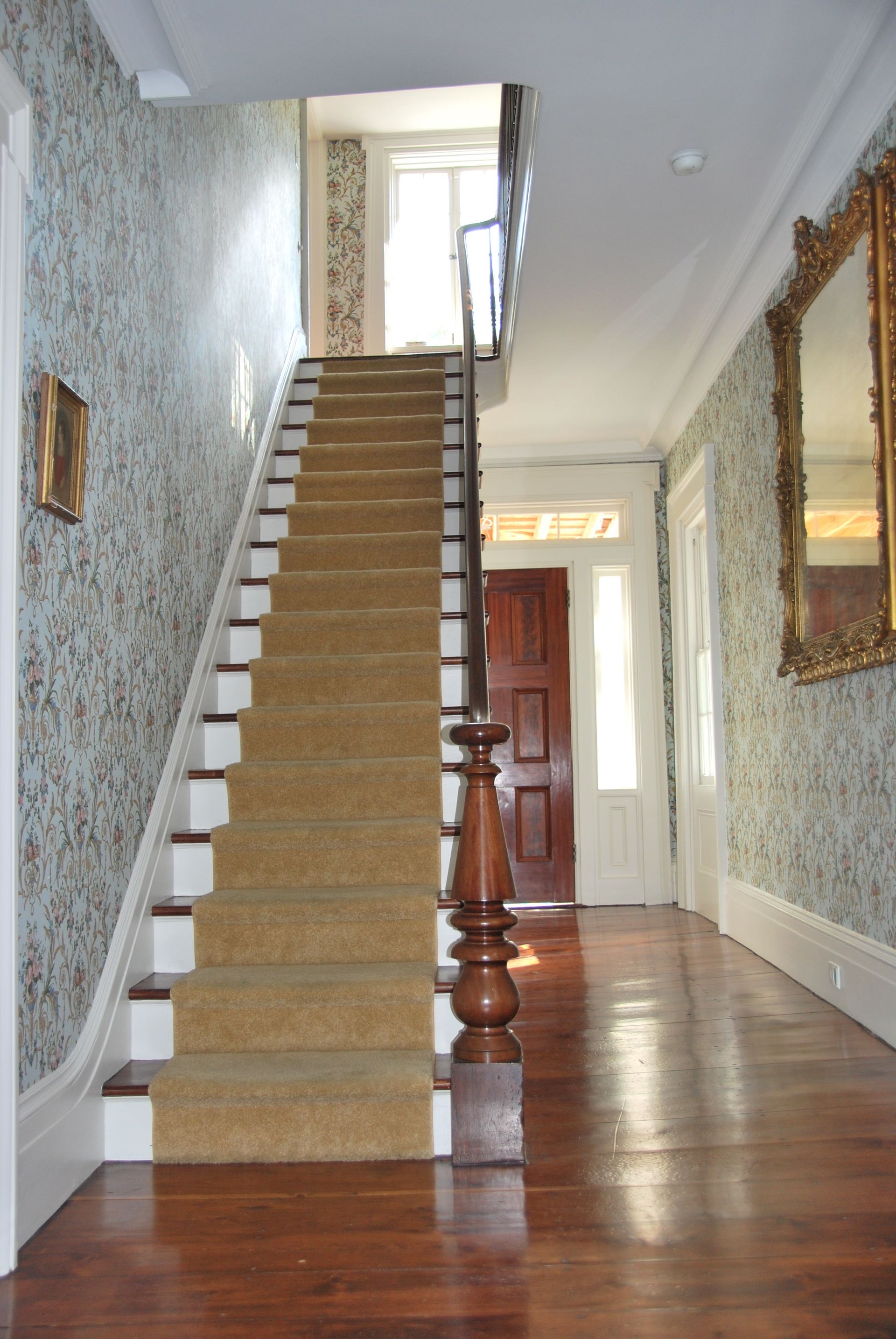 A hallway with a staircase leading up to the second floor