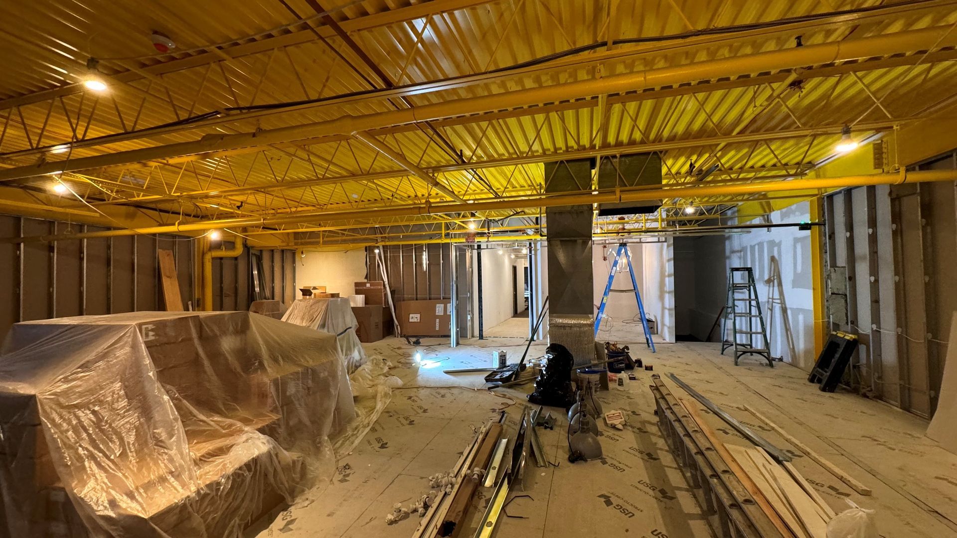 A large room with a ceiling that is being built.