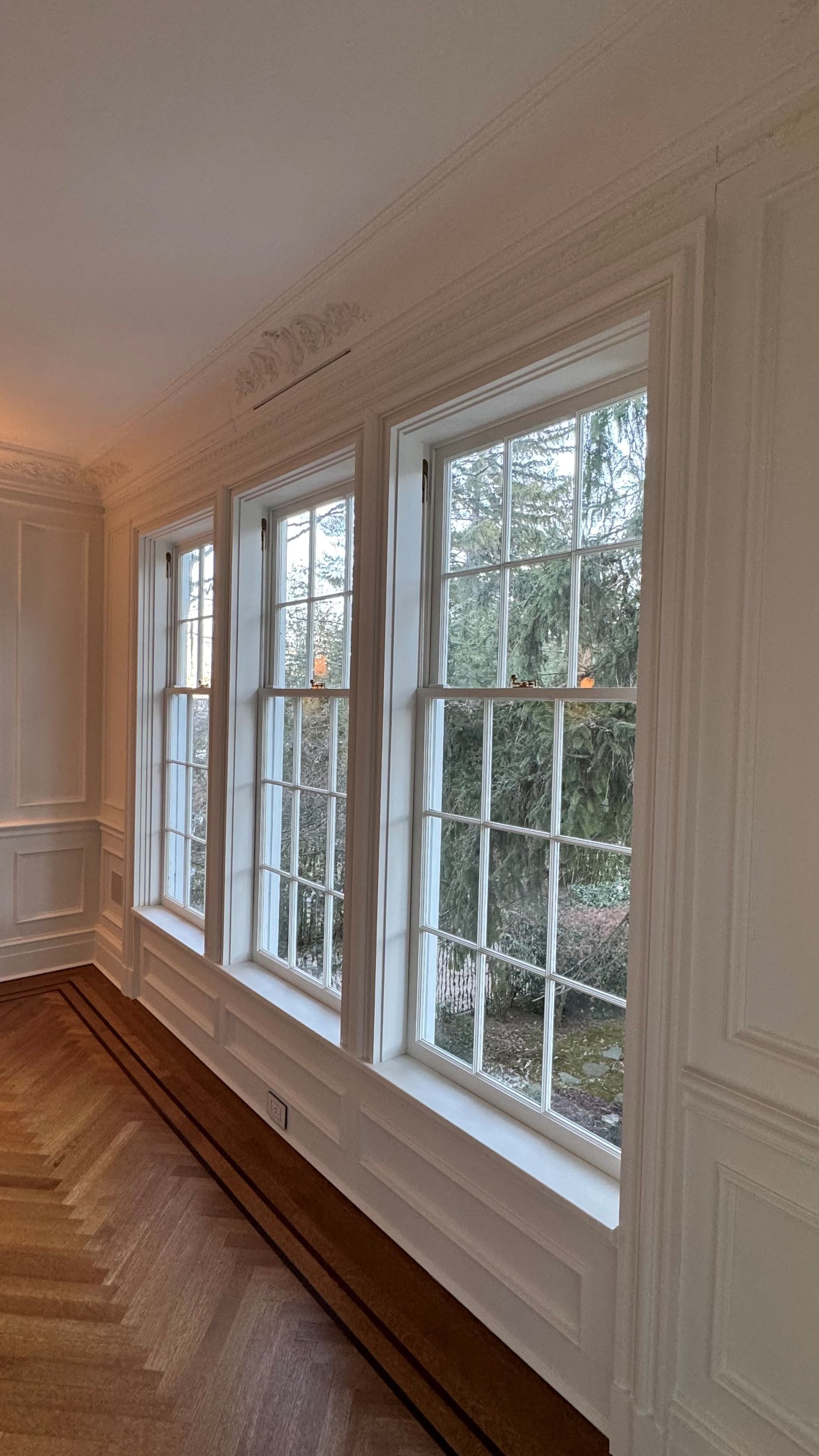 A room with a lot of windows and a wooden floor.