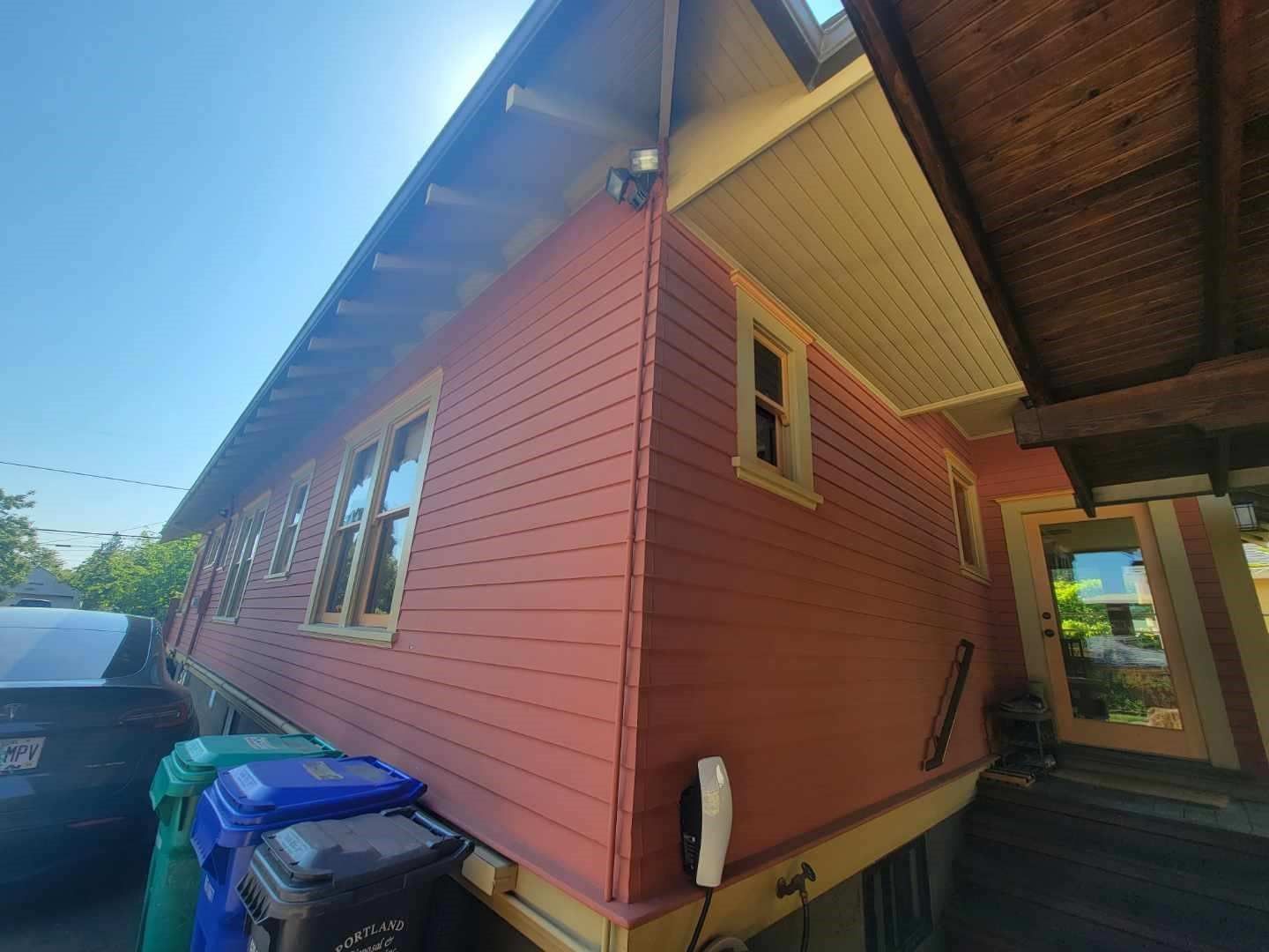 a pink house with a lot of windows and a car parked in front of it