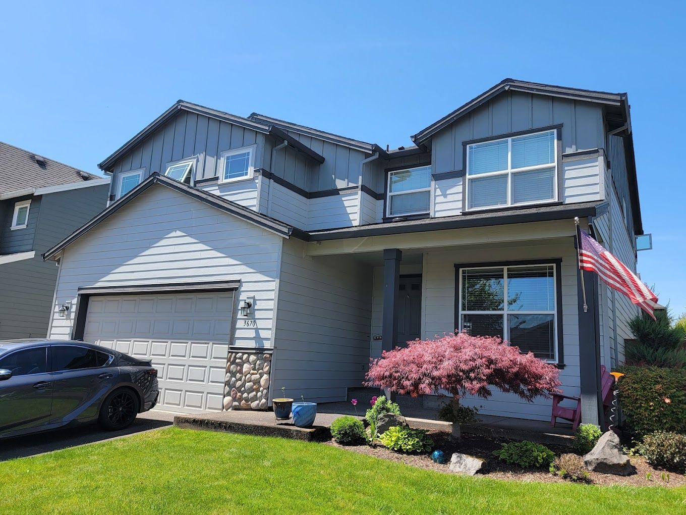 A car is parked in front of a large house.
