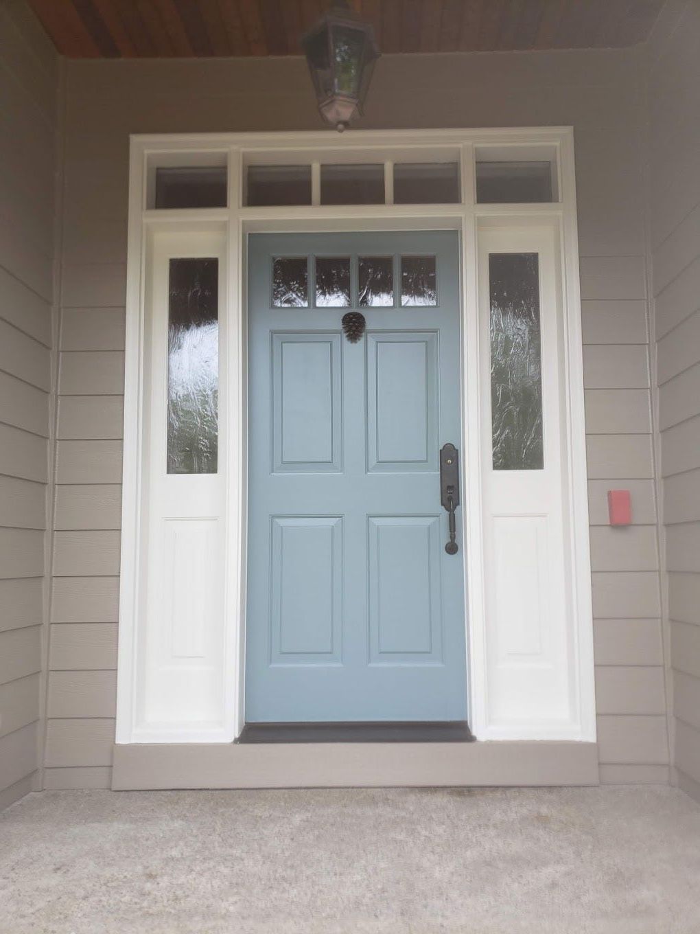 The front door of a house has a light above it.