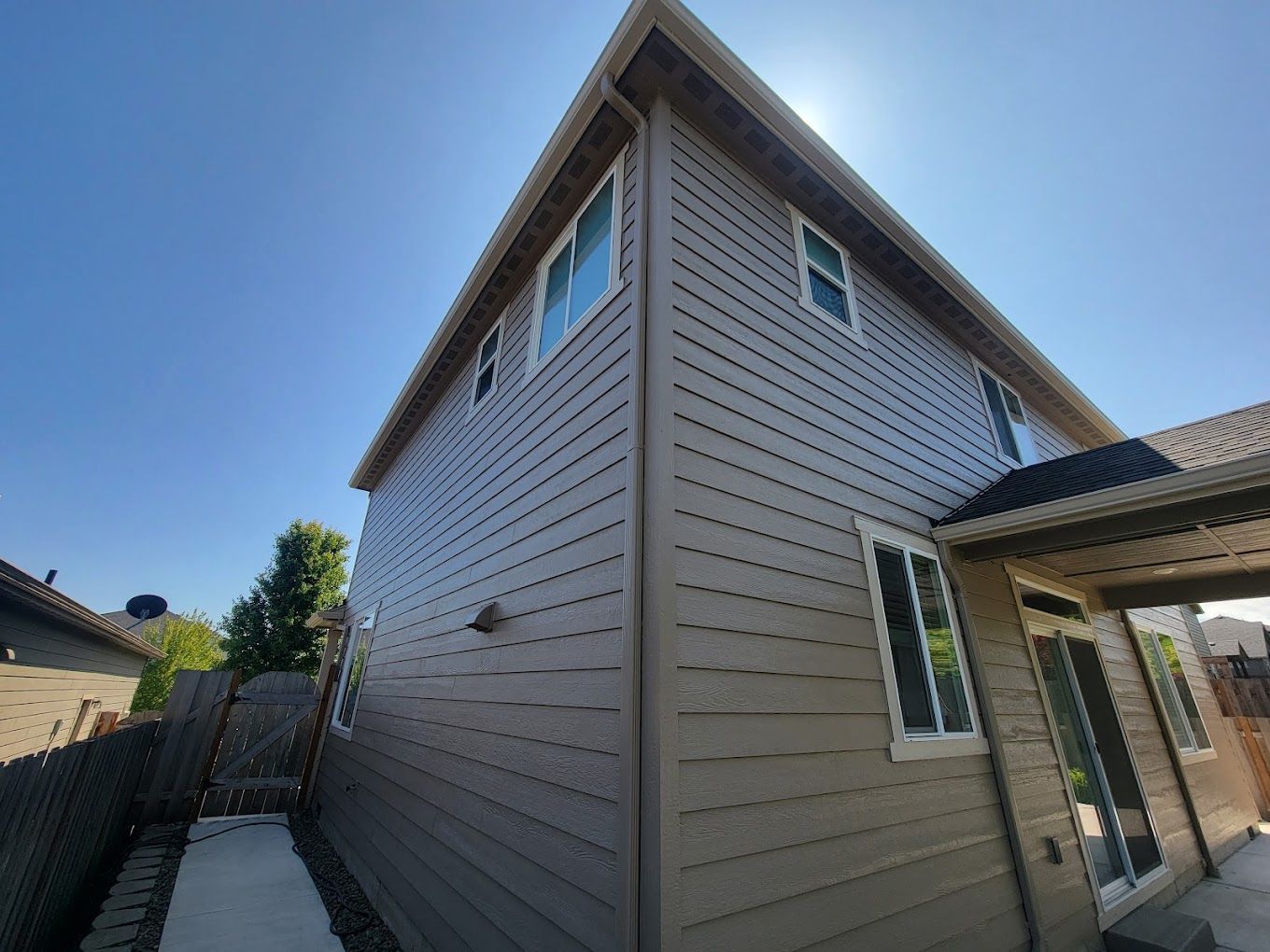 A large house with a lot of windows and a blue sky in the background.