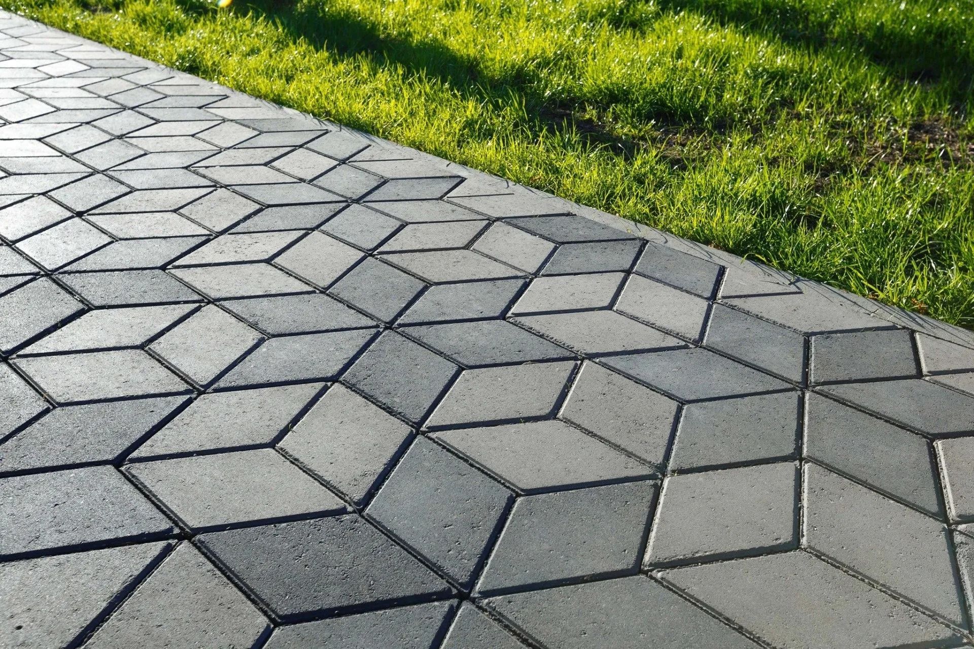 Gray geometric stone walkway beside green grass