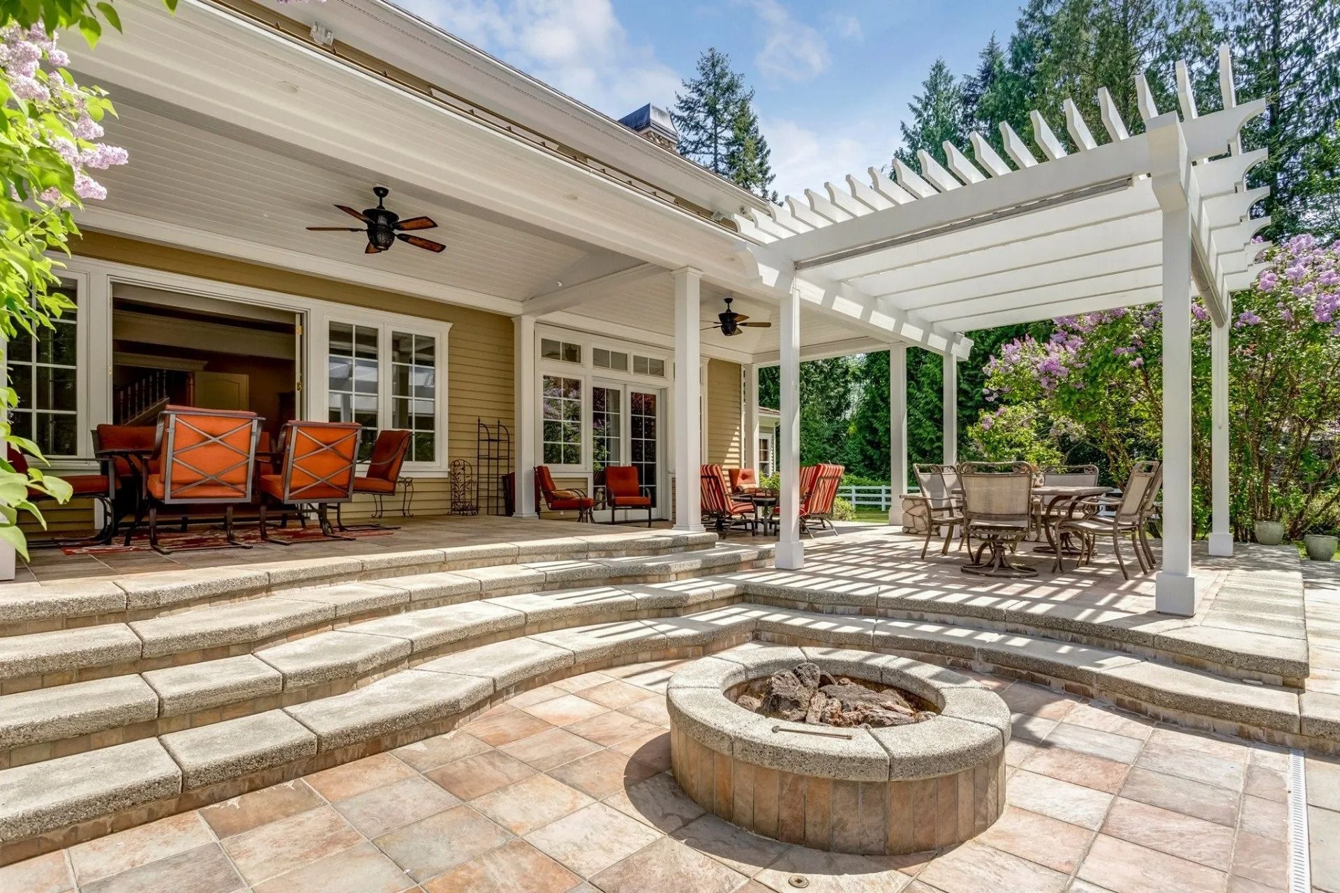 Patio with fire pit, steps, pergola, and covered porch with outdoor seating