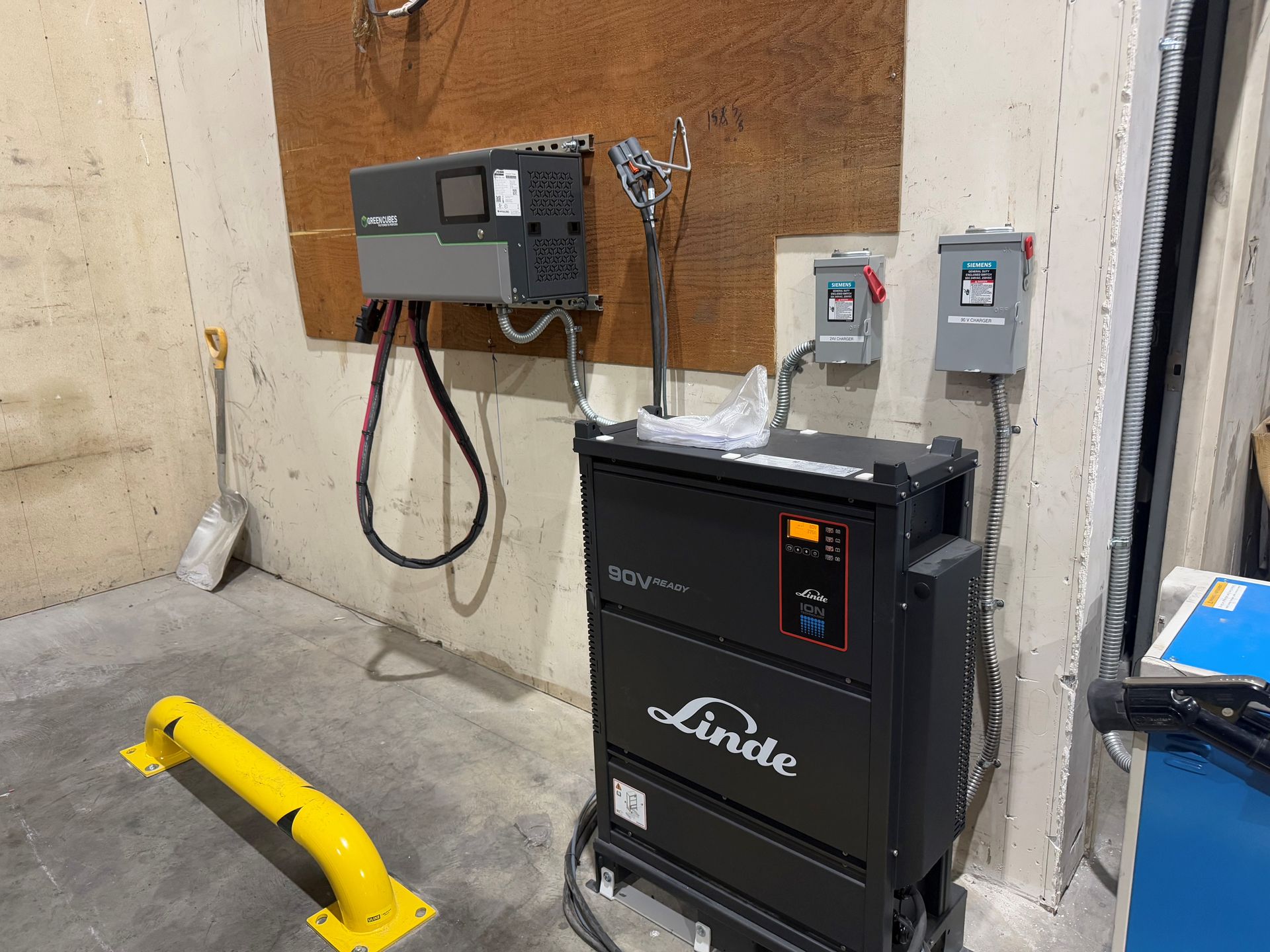 A Linde machine is sitting in a warehouse next to a wall.