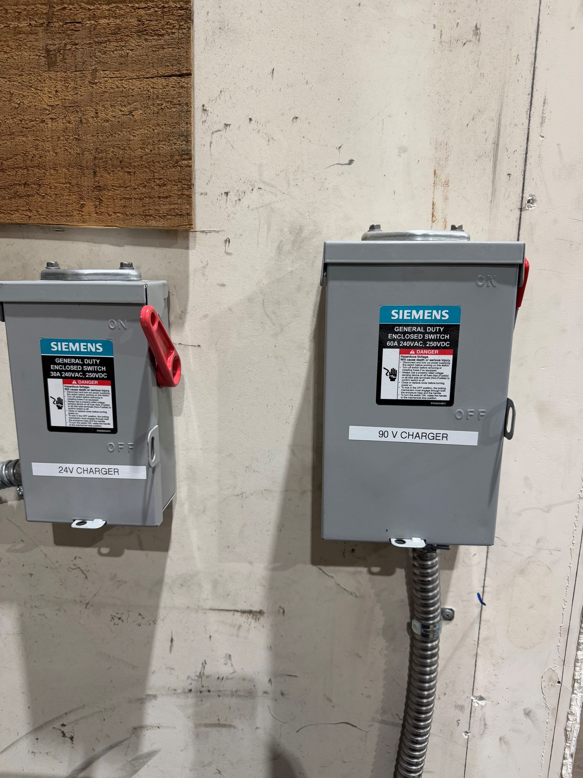 Two electrical boxes attached on a wall.