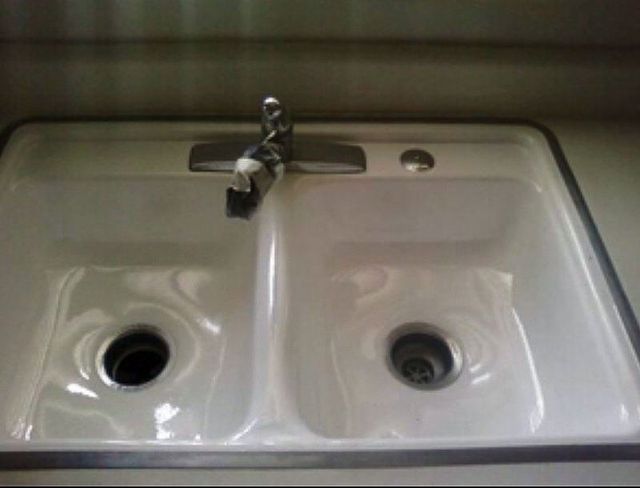 White, double-basin kitchen sink with faucet, seen from above.